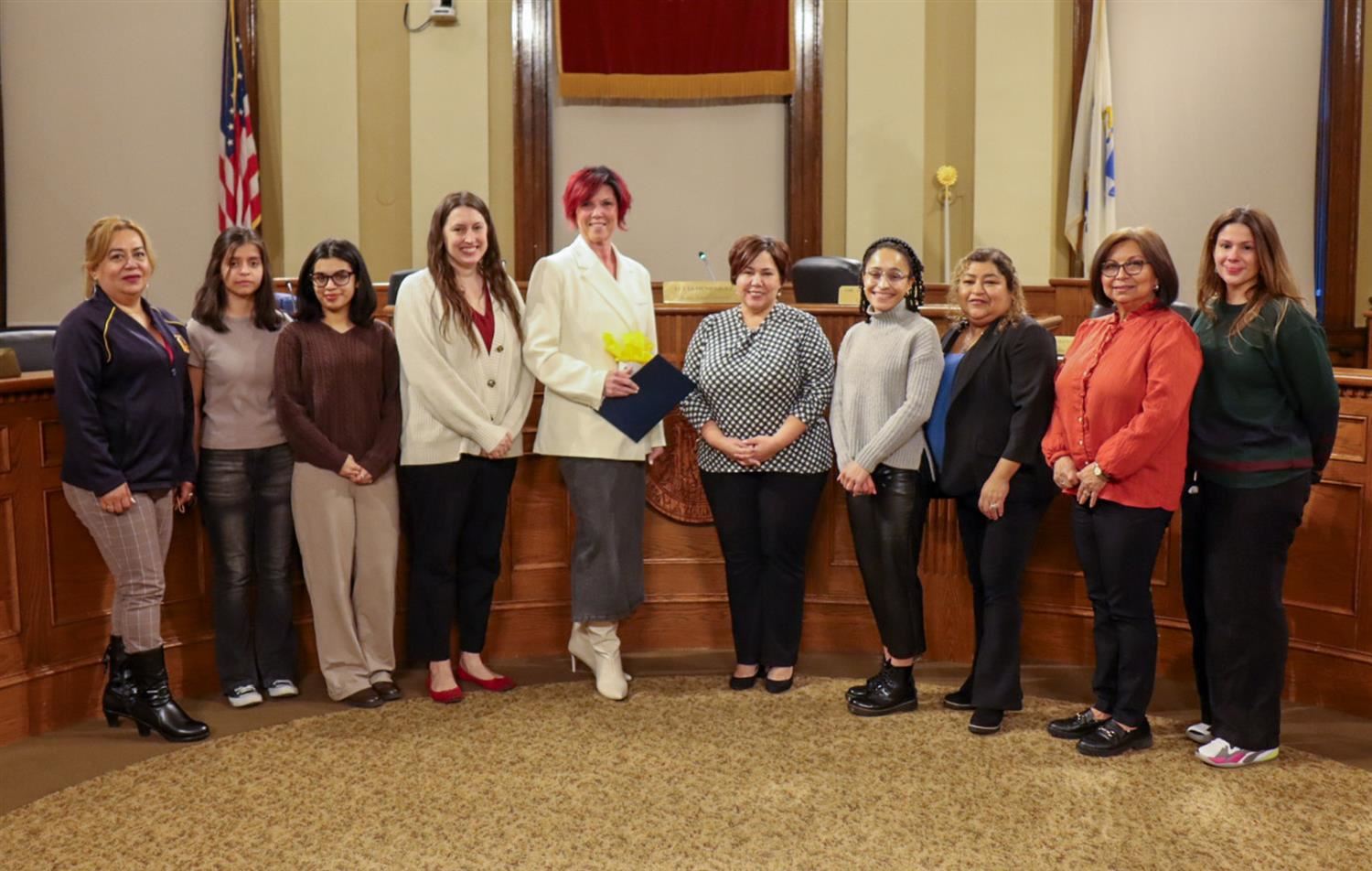 Stacey Gurska photographed with a Name Strength and Story Award alongside the Chelsea School Committee